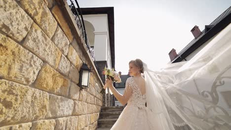 Hermosa-Y-Encantadora-Novia-Con-Vestido-De-Novia-Se-Encuentra-En-Los-Escalones-De-Piedra.-Cámara-Lenta