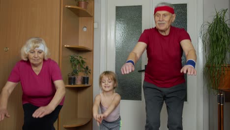 Senior-couple-with-granddaughter-doing-workout,-training,-fitness,-sport-activity-exercises-at-home