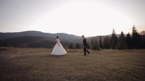 Newlyweds.-Caucasian-groom-with-bride-on-mountain-slope.-Groom-proposes