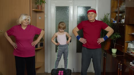 Active-senior-couple-grandmother-grandfather-with-child-kid-girl-doing-fitness-stretching-exercises