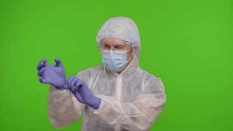 Arzt-Im-Gesundheitswesen-Steht-Auf-Chroma-Key-Und-Zieht-Handschuhe-Und-Maske-An,-Coronavirus-Pandemie