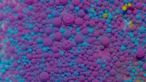 Movement-of-blue-purple-oil-ink-drops-bubbles,-multicolored-artistic-paint-surface-background