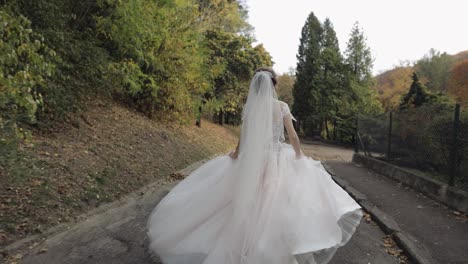 Hermosa-Y-Encantadora-Novia-Con-Vestido-De-Novia-Corriendo-En-El-Parque.-Cámara-Lenta