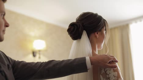 Newlyweds-young-caucasian-bride-and-groom-first-meeting-at-wedding-day,-making-a-kiss-indoors