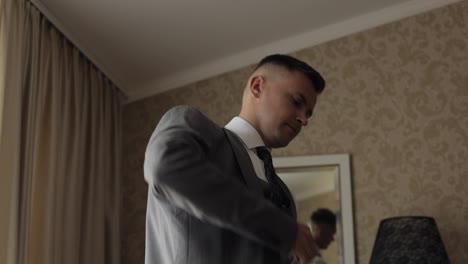 Handsome-groom-businessman-wearing-gray-jacket-at-home-in-living-room,-white-shirt-with-black-tie