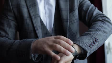 Man-put-on-wrist-watch.-Groom-dresses.-Male-businessman-is-waiting-for-meeting.-Hand-with-clock