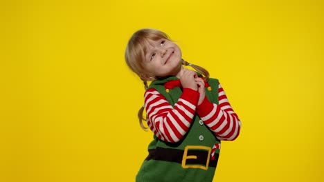 Christmas-wish-concept.-Kid-teen-girl-in-Christmas-elf-Santa-helper-costume-making-a-wish,-prays