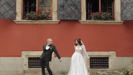 Newlyweds,-lovely-wedding-caucasian-bride-and-groom-dancing-trendy-dance-celebrating-in-city-street