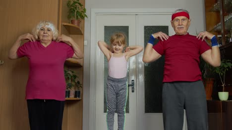 Active-senior-couple-grandmother-grandfather-with-child-kid-girl-doing-fitness-stretching-exercises