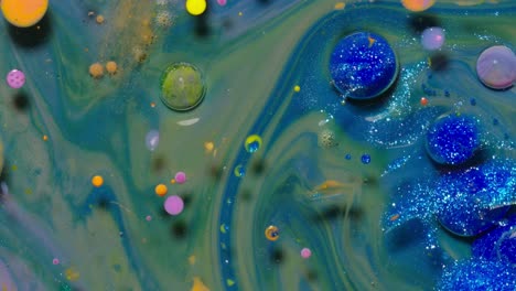 Top-view-movement-of-blue-oil-ink-drops-bubbles,-multicolored-artistic-paint-surface-background