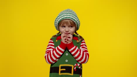 Kid-girl-Christmas-elf-Santa-helper-steepls-fingers-waiting-for-gift-box.-Child-in-New-Year-holidays