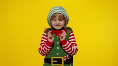 Christmas-wish-concept.-Kid-teen-girl-in-Christmas-elf-Santa-helper-costume-making-a-wish,-prays