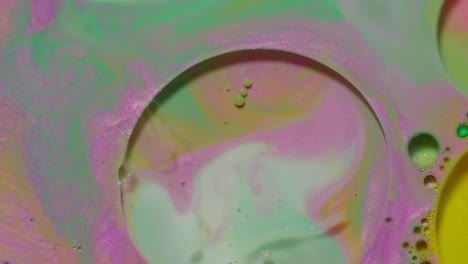 Ink-bubbles-mixed-with-liquid-substance-of-oil,-milk,-soap,-bright-acrylic-paint-on-colorful-surface