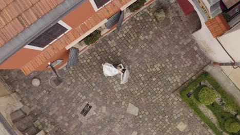 Lovely-newlyweds-caucasian-bride-groom-dancing-on-city-street,-wedding-couple-family,-aerial-view