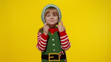 Christmas-wish-concept.-Kid-teen-girl-in-Christmas-elf-Santa-helper-costume-making-a-wish,-prays