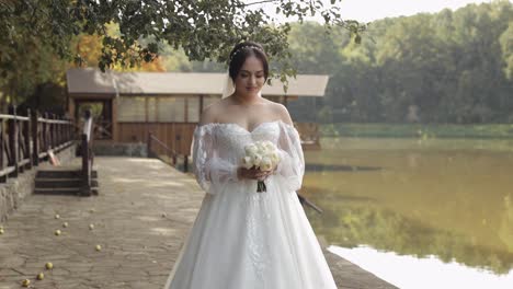 Hermosa-Novia-Elegante-Con-Vestido-De-Novia-Blanco-Y-Velo-Sosteniendo-Ramo-De-Novia-En-Las-Manos-En-El-Parque