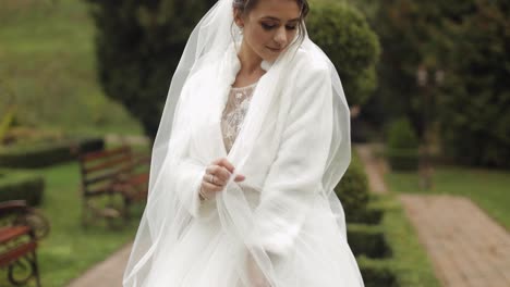 Hermosa-Y-Encantadora-Novia-Con-Vestido-De-Novia-Y-Velo-En-El-Parque-Esperando-Al-Novio.-Camara-Lenta