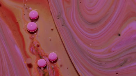 Top-view-movement-of-pink-oil-ink-drops-bubbles,-multicolored-artistic-paint-surface-background