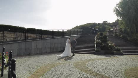 Lovely-newlyweds-caucasian-bride-groom-walking-in-park,-holding-hands,-wedding-couple-family