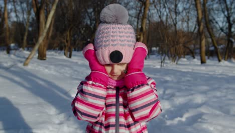 Cheerful-child-girl-shows-wow-delight-effect-gesture,-kid-raising-hands-in-surprise-in-winter-park