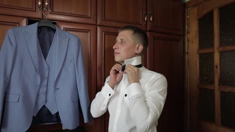 Groom-adjusts-bow-tie.-Preparing-to-go-to-the-bride.-Businessman.-Wedding-day