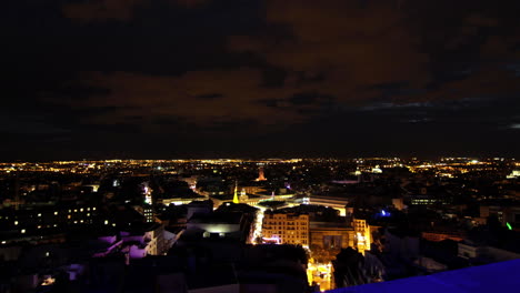 Dramatische-Nachtansicht-Einer-Skyline-Der-Innenstadt-Von-Madrid-Mit-Einem-Dunklen,-Bewölkten-Himmel-Und-Vereinzelten-Lichtern,-Die-Die-Städtische-Landschaft-Darunter-Beleuchten