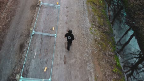 Vista-Aérea-De-Un-Hombre-Corriendo-Por-El-Bosque-En-Busca-De-La-Libertad