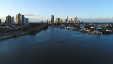 Un-Dron-Aéreo-Desciende-Lentamente-Siguiendo-A-Un-Pequeño-Grupo-De-Kayakistas-Que-Disfrutan-De-Un-Paseo-Matutino-Por-El-Broadwater-De-Southport,-Gold-Coast,-Australia,-Durante-El-Amanecer