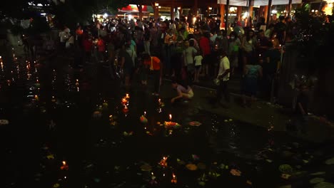 Während-Der-Loi-Krathong-Feierlichkeiten-In-Korat,-Thailand,-Beten-Die-Menschen-Und-Stellen-Schwimmende-Kerzen-Auf-Die-Kanäle-Der-Stadt