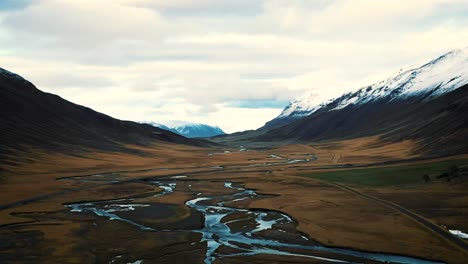 Drone-straight-fly-over-dramatic-landscape-of-Iceland---river-mountains