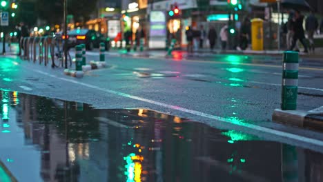 Carril-Bici-Con-Charco-En-La-Calle,-Bicicleta-Y-Patinete-Eléctrico-Pasando-Por-El-Agua-En-Una-Noche-Lluviosa