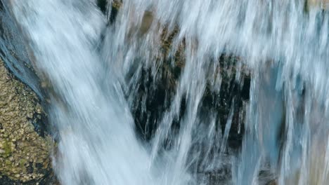 Close-up-of-rushing-water-flowing-over-rocks-in-Walenstadt,-Kanton-St