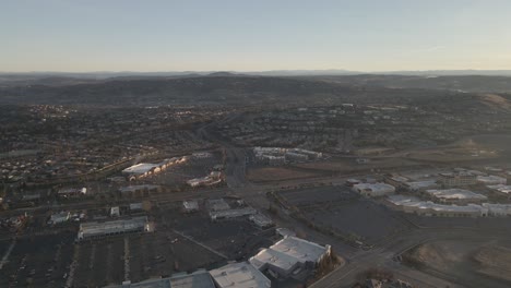 Weitwinkel-Drohnenaufnahmen-Aus-Der-Vogelperspektive-An-Einem-Sonnigen,-Nebligen-Morgen-über-Den-Straßen-Von-Folsom,-USA,-Mit-Häusern,-Gebäuden-Und-Straßen-Im-Vordergrund-Und-Bergen-In-Der-Ferne