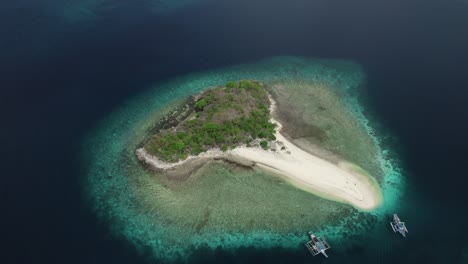 Aerial-view-of-a-remote,-desolate-island-surrounded-by-blue-waters-and-white-sands