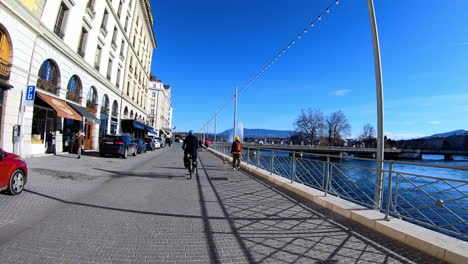 A-vélo-sur-le-Quai-des-Bergues-à-Genève,-Suisse