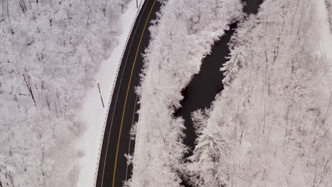 Luftaufnahme-Einer-Winterstraße,-Die-Sich-Nach-Einem-Winterschneesturm-Durch-Einen-Gebirgspass-Schlängelt