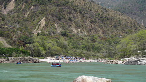 Blick-Auf-Rishikesh-Vom-Tapovan-Flussufer-Am-Morgen-Mit-Rafting-Touristenbooten,-Die-Auf-Dem-Ganges-Segeln