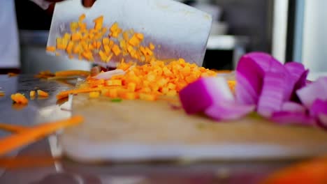 Chef-Cortando-Zanahorias-En-Una-Tabla-De-Cortar-Blanca