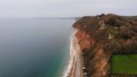 Erstaunliche-4K-Luftaufnahme-über-Dem-Meer,-Die-Sanft-In-Richtung-Der-Küstenberge-Des-Luxuriösen-Strandes-Von-Branscombe-Schwenkt