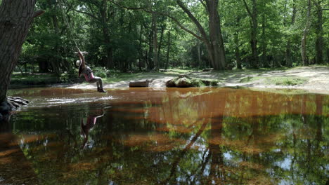 Una-Mujer-India-Disfruta-De-Un-Columpio-En-Un-Pequeño-Río-En-Un-Bosque-Nuevo