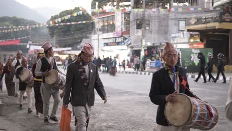 Personas-Nepalesas-Vestidas-Con-Trajes-Tradicionales-Y-Llevando-Instrumentos-Musicales-Tradicionales-Caminando-Por-La-Carretera-Con-La-Tripulación.