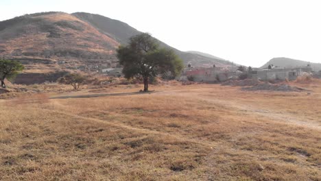 4k-Drone-flying-over-grass-field,-scenic-hill-region-in-Alta-California,-Mexico