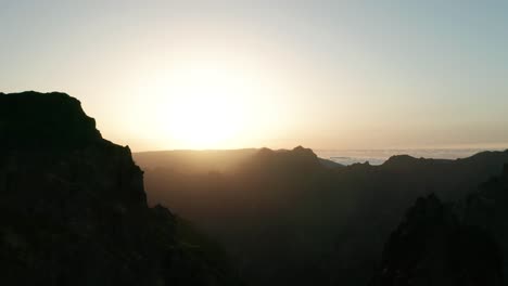 Truck-right-aerial-of-spectacular-mountain-range-during-bright-golden-sunset