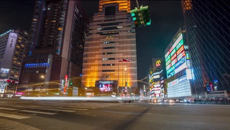 Panning-View-of-Night-City-Time-Lapse-From-Left-to-Right-at-Zhongxiao-West-Road-Busy-Intersection-with-Traffic-and-Pedestrians-in-Metropolitan-Taipei-Taiwan