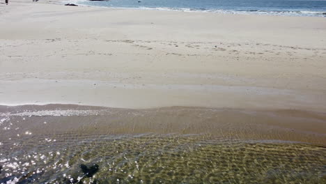 Drone-Volando-Sobre-La-Playa-Con-Laguna-En-El-Tercio-Inferior-Y-Océano-En-El-Tercio-Superior