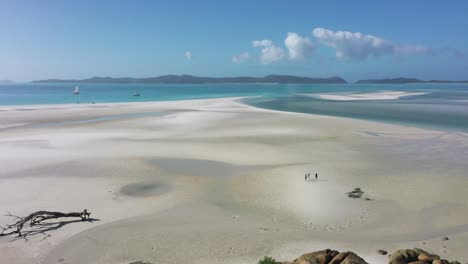 Four-young-people-explore-expansive-beach-on-Whitehaven-Beach,-QLD