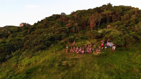 Aerial-Rotation-Drone-Shot-of-People-Watching-Sunrise-on-Mountain-in-Florianopolis,-Brazil