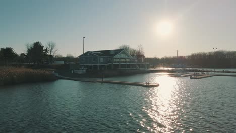 Drone-footage-of-a-person-walking-across-a-lake-dock-at-sunset