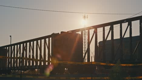 Tren-De-Carga-Moviéndose-En-Cámara-Lenta-Durante-La-Hora-Dorada-Con-Destellos-De-Sol-Cinematográficos