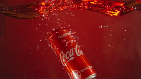 Coca-Cola-can-falls-into-water-in-a-small-aquarium-in-slow-motion-with-a-red-background-for-use-in-advertisements